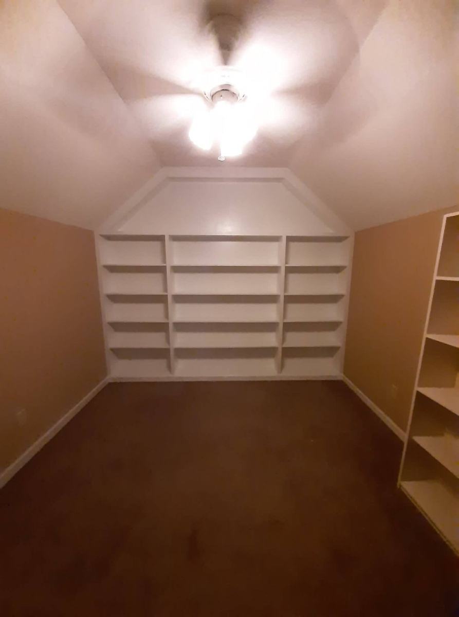 Completed painted built-in shelving with trim in a finished room.