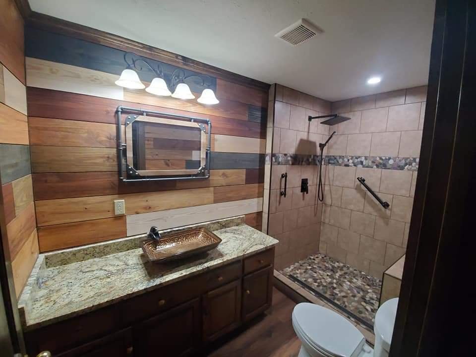 Bathroom with wood accent wall, vessel-sink vanity and tile shower by MMAC Renovation