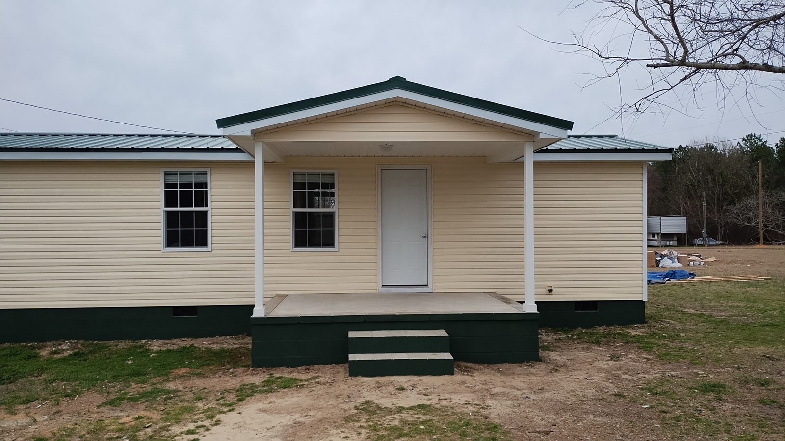 Finished home exterior with covered porch and fresh trim by MMAC Renovation