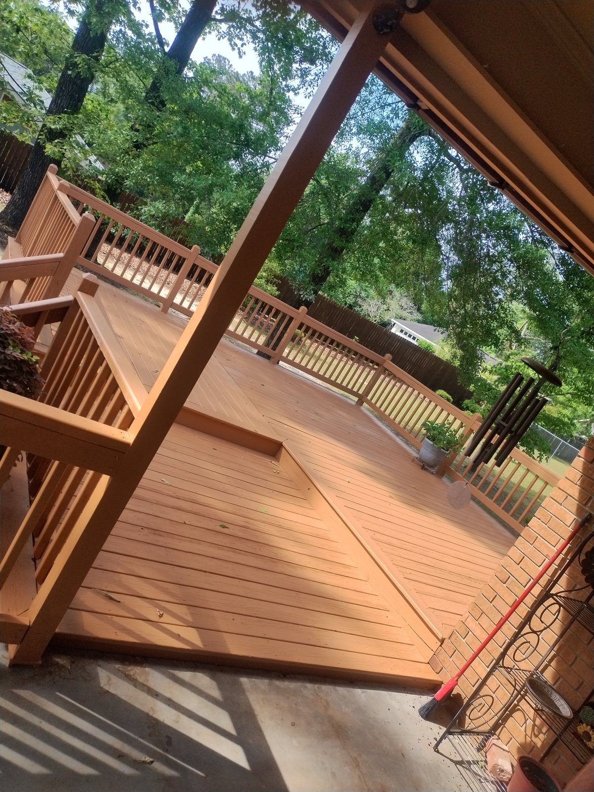 Freshly re-stained covered wood deck with railing by MMAC Renovation, Laurens County GA