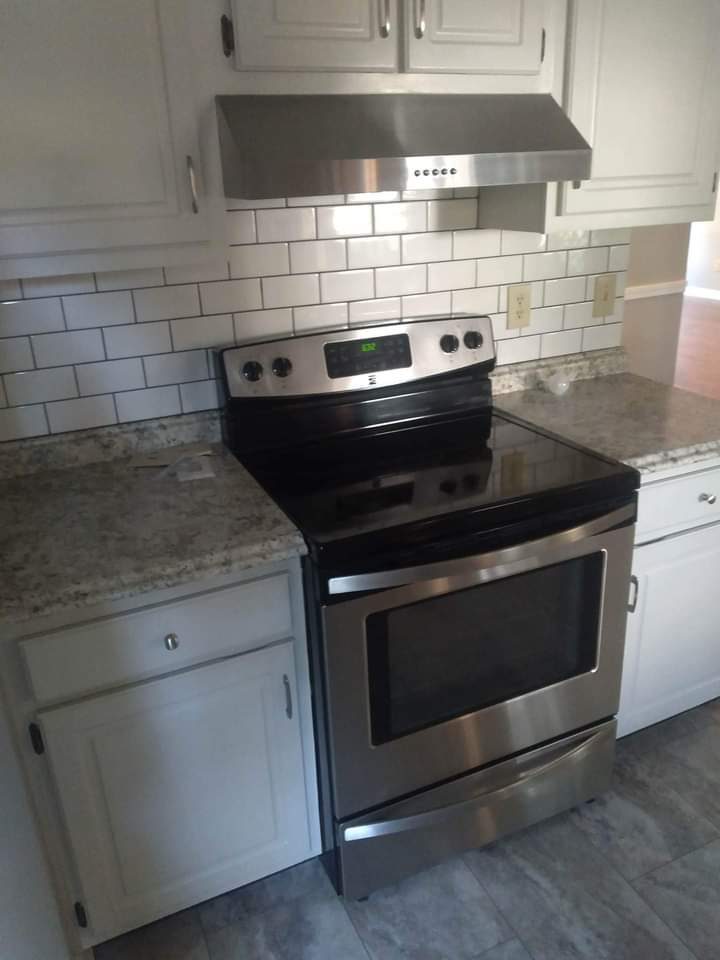 Finished kitchen with white shaker cabinets, subway-tile backsplash, and stainless range — MMAC Renovation, Laurens County GA