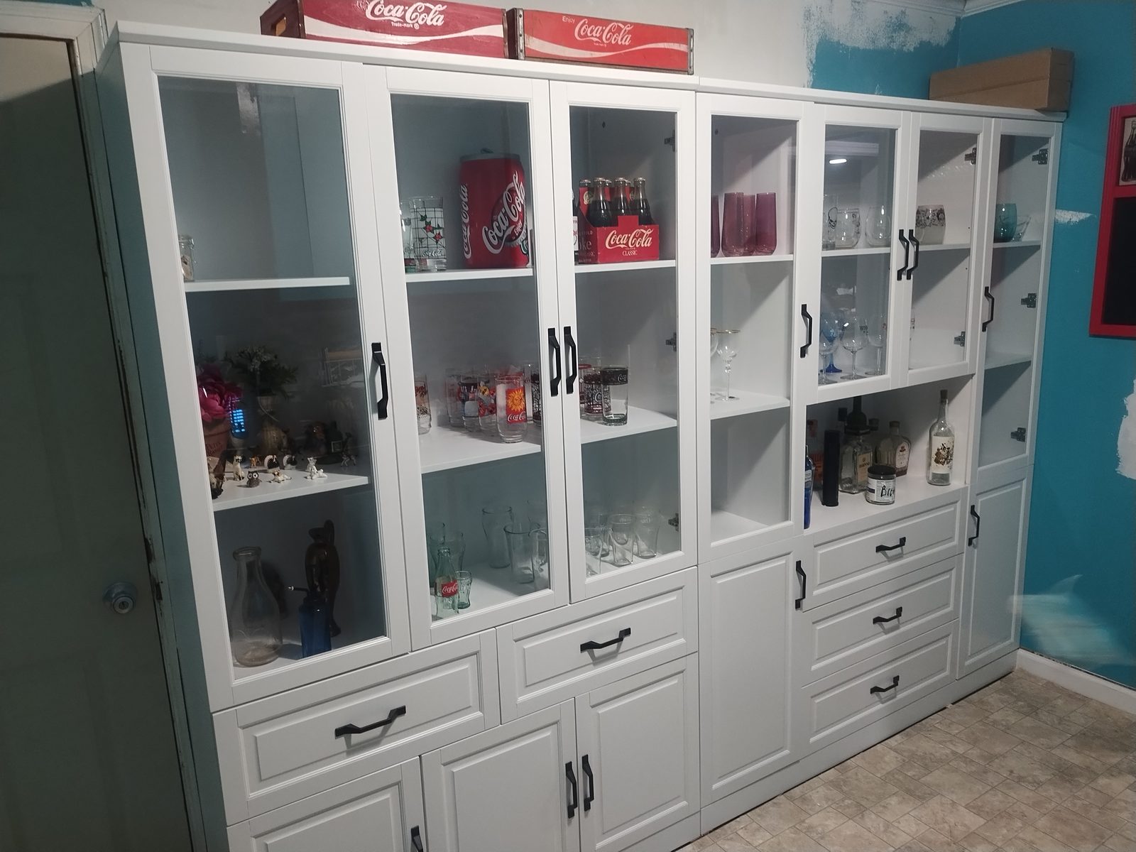 Custom white built-in display cabinet with glass doors in a kitchen by MMAC Renovation